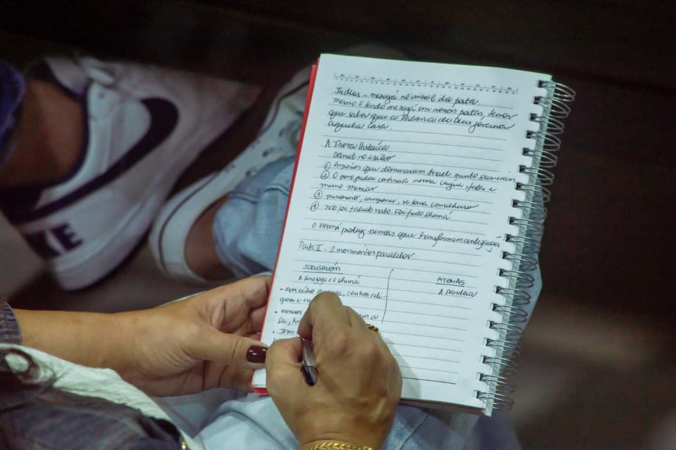 Caderno de anotações aberto ao lado de uma Bíblia